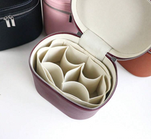 Load image into Gallery viewer, A close-up of an open zippered organizer case with a mauve exterior and cream interior compartments, shown on a white surface with other cases partially visible in the background.
