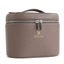 Load image into Gallery viewer, A taupe brown pebbled leather cosmetic case with a top handle and a silver zipper closure, shown against a plain white background.
