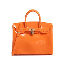 Load image into Gallery viewer, Orange personalized Beachkin tote bag from Travellers Hat Boutique with top handles and lock detail

