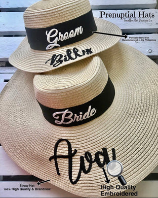Custom prenuptial hat set featuring groom and bride straw hats with black bands and embroidered names