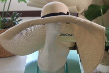 Load image into Gallery viewer, Oversized straw sun hat with wide brim and black band displayed on a white mannequin head
