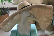 Load image into Gallery viewer, Oversized straw sun hat with wide brim and black ribbon from Travellers Hat Boutique displayed on mannequin
